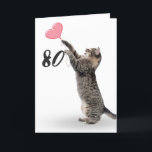 juguetón tabby para la tarjeta de cumpleaños númer<br><div class="desc">Gato grisáceo con globo de corazón rosa por 80 años sobre fondo blanco.
Se puede cambiar el color de fondo</div>