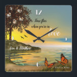 Las mariposas aman el reloj de pared del lago Suns<br><div class="desc">Reloj romántico con un cuadro de la puesta de sol frente al mar con mariposas y un árbol floreciente. ¡Un gran regalo boda,  un regalo El día de San Valentín o un regalo para cualquier ocasión romántica!</div>