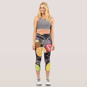 Leggings Capri Frutas tropicales coloridas, fondo negro.