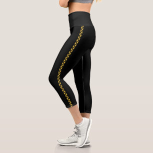 Leggings Capri negros con franja lateral dorada at