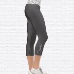 Leggings Capri Símbolo Om botánico de alta eliminación de capri<br><div class="desc">Patrón botánico colorido El símbolo Om está embaldosado en la cintura, las leggings capri son de gris oscuro. Nombre en gris claro en el exterior del becerro derecho. Cambiar o quitar fácilmente el nombre mediante la plantilla proporcionada. Hay amplio espacio para un nombre completo u otro texto. Tamaños de XS...</div>