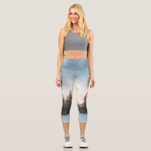 Leggings Capri Sol detrás de árboles de abeto