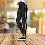 Leggings Leggencias negras elegantes con banda lateral Nara<br><div class="desc">Estas elegantes y confortables leggings negras con una audaz franja lateral naranja son la adición perfecta a su armario casual. Diseñadas tanto para la puesta en forma como para la moda, ofrecen un estilo de ajuste y atractivo. Ya sea que vaya al gimnasio o haga recados, estas leggings proporcionan la...</div>