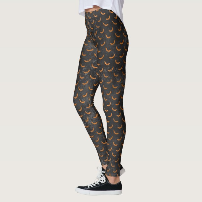 Leggings Naranja murmurando sobre fondo negro oscuro (Izquierda)