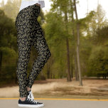 Leggings Patrón de hoja verde sobre negro<br><div class="desc">Este diseño de estilo natural presenta una rama verde y un patrón de hoja sobre un fondo negro.</div>