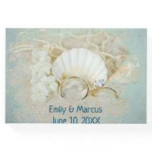Anillos bodas y conchas marinas en arena