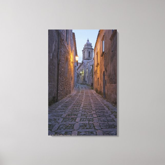 Lienzo Calle empedrado del casco antiguo iluminado por la (Anverso)