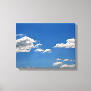 Lienzo El cielo es azul y las nubes blancas están pasando