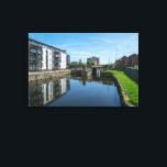 Lienzo Fall Ings Lock, Wakefield<br><div class="desc">A bright, high-resolution photograph capturing the modern waterfront development along the Calder & Hebble Navigation in Wakefield. The image showcases a large white and wood-clad apartment complex with glass balconies, perfectly mirrored in the still canal water. In the mid-ground, the stone structures of Fall Ings Lock and a pedestrian bridge...</div>