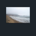 Lienzo Foggy Morning on South Bay Beach, Scarborough<br><div class="desc">An atmospheric and moody scene of South Bay Beach in Scarborough, North Yorkshire, enveloped in a dense morning fog. Gentle waves lap at the sandy shore in the foreground, creating a foamy edge. The mist partially obscures the vibrant lights of the town and harbor, giving Scarborough a mysterious and ethereal...</div>