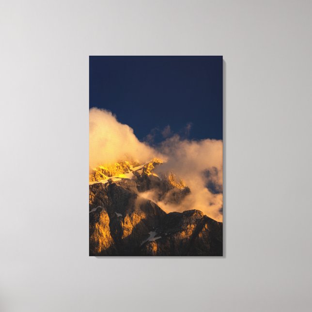 Lienzo Montañas iluminadas por el sol cubiertas de nubes (Anverso)