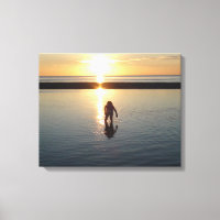 Niña jugando al atardecer en agua de marea baja