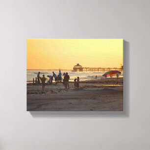 Lienzo Personas en la playa del océano al atardecer