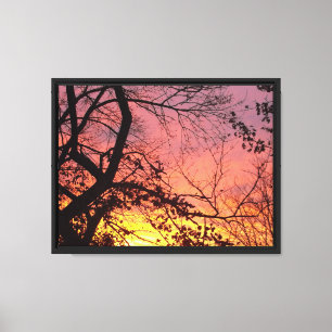 Lienzo Puesta de sol colorida a través de árboles desnudo