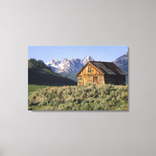 Lienzo Una cabaña de troncos y las montañas Sawtooth en