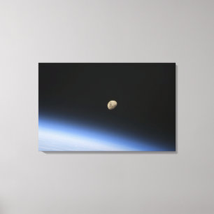 Lienzo Una luna gibosa visible sobre la atmósfera de