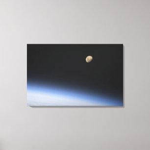 Lienzo Una luna gibosa visible sobre la atmósfera de