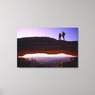 Lienzo Una pareja observa el amanecer desde la cima del A