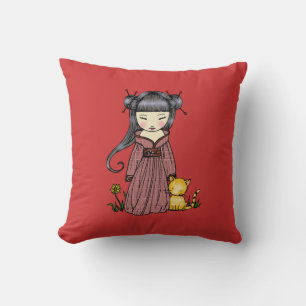 Linda niña japonesa con su almohada de gato