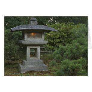 Linterna de piedra iluminada en un jardín japonés