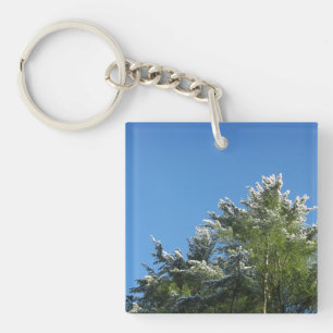 Llavero Árbol de pino con punta de nieve en cielo azul