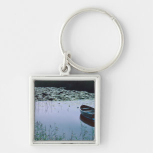 Llavero Barca de remos en un pequeño lago rodeado de agua