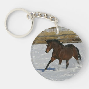 Llavero Caballo tostado corre en la nieve