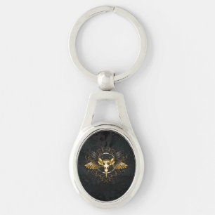 Llavero Calavera de pájaro dorado sobre fondo negro