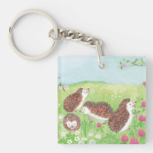 Llavero Cuatro pequeños erizos en el prado floreciente
