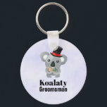 Llavero Cute Koala Pun Koalaty Groomsman<br><div class="desc">Un llavero con un lindo oso koala con un sombrero de top negro con una cinta roja. Agradable y peludo. El texto dice Koalaty Groomsman. Un juego de palabras divertido. Se coloca sobre un fondo morado claro.</div>