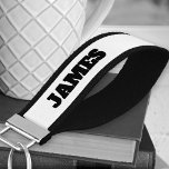 Llavero De Pulsera Añadir su nombre tipografía negrita en blanco y ne<br><div class="desc">Cadena de teclas de muñeca personalizada con tu nombre impreso en ambos lados. Este diseño sencillo y minimalista presenta tipografía de titulares audaces en una paleta de colores mínima de blanco y negro.</div>