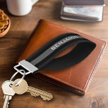 Llavero De Pulsera Bandas de rugby negras y grises con nombre persona<br><div class="desc">Un patrón masculino para los chicos y chicos de tu familia. Un diseño audaz y moderno con un área para texto personalizado. Si necesita ajustar la ilustración o cambiar el tipo de letra, puede hacer clic en el área personalizar. Esto le llevará a la herramienta de diseño donde puede hacer...</div>