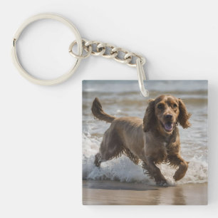 Llavero "Diversión costera: Cocker Spaniel juega en el océ
