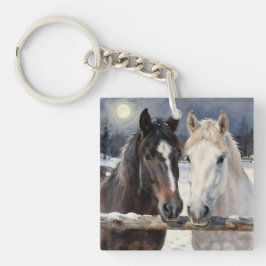 Llavero Dos caballos en una granja nevada bajo la luna