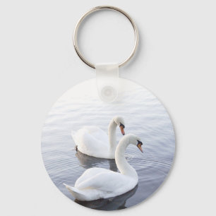 Llavero Dos cisnes nadando en un lago tranquilo