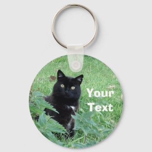 Llavero El gato negro de Halloween en hierba mira el