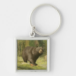 Llavero El oso negro pisando un tronco de árbol