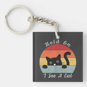 Llavero Espera, veo una mirada de gato, juguetón y humorís