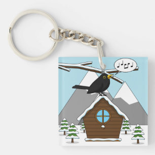 Llavero Feliz Canto de Blackbird en el paisaje invernal