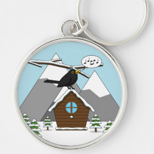 Llavero Feliz Canto de Blackbird en el paisaje invernal