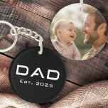 Llavero Foto negra del recién nacido del día del padre del<br><div class="desc">Keychain presenta el texto "Papá" en una letra moderna con el año siguiente. En la parte trasera hay una plantilla de fotos de personalizable. Los colores predeterminados son negro y blanco,  pero todos los colores se pueden personalizar en la herramienta de diseño.</div>