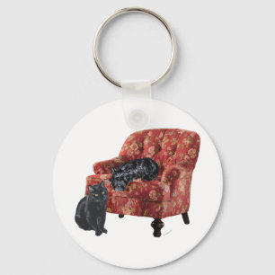 Llavero Gato negro y terrier escocés en una silla roja