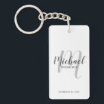 Llavero Groomsmen personalizado de escritura moderna<br><div class="desc">Añada un toque personal a su boda con la cadena de teclas personalizada para los groomsmen. Esta cadena de claves presenta el nombre de los groomsmen personalizados en estilo de letra de escritura moderno gris y monograma en estilo de letra de escritura moderno gris claro como fondo con título y...</div>