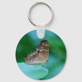 Llavero Hermosa mariposa Danaus Plexippus en hojas.