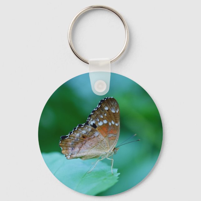 Llavero Hermosa mariposa Danaus Plexippus en hojas. (Anverso)