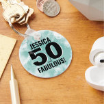 Llavero Hitos 50.º cumpleaños fabuloso<br><div class="desc">Una mezcla de escritura linda y audacia moderna con este diseño simple de "50 y fabuloso"! Con un colorido clásico en blanco y negro con un toque de color del fondo de color azul verde azulado (o turquesa claro). Personalizar al nombre, y si lo necesitas, también puedes cambiar el 'y'...</div>