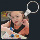 Llavero Keychain<br><div class="desc">Gillie’s art collection was inspired by creativity, curiosity, and a hands-on experience shared with classmates. Together, they created their artwork using the very tool they made themselves—colored popsicles on a stick. By mixing paint and water, freezing it, and using the melting ice to glide across the canvas, Gillie was able...</div>