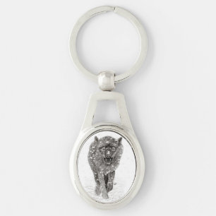 Llavero Lobo negro enojado en la nieve, invierno salvaje