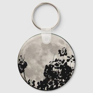 Llavero Luna detrás de hojas oscuras