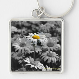 Llavero margarita amarilla en un mar de margaritas negras